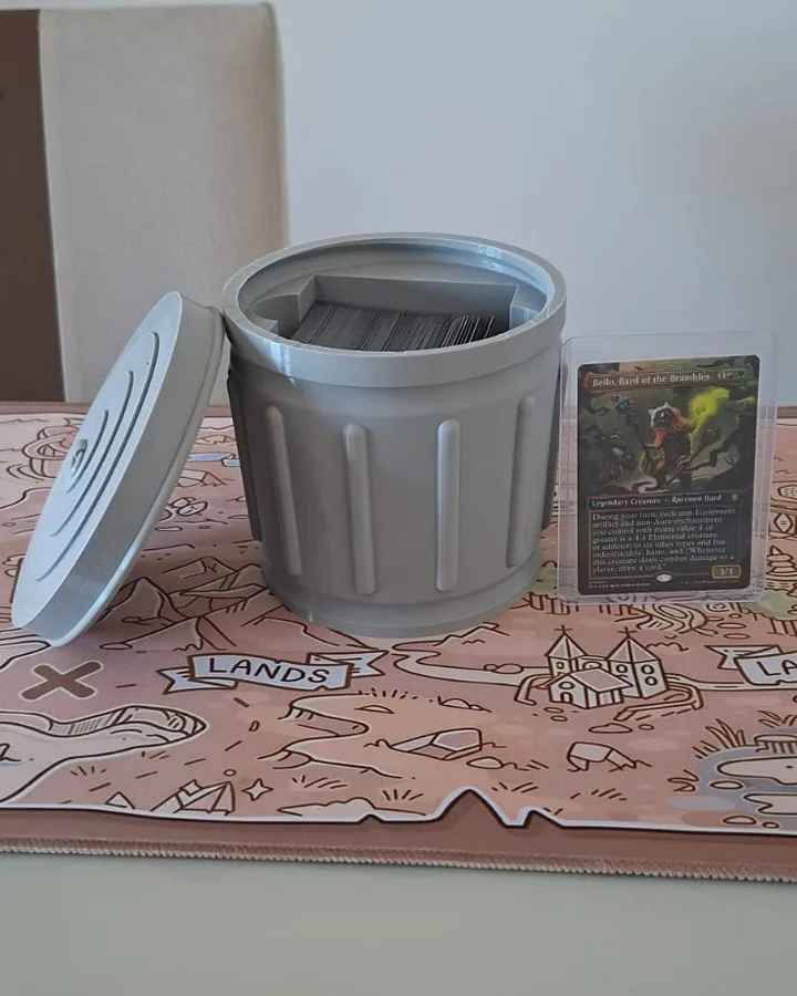 A mesma deck box lixeira aberta, com a tampa apoiada ao lado e as cartas guardadas dentro