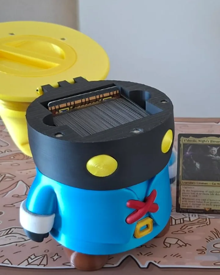 A mesma deck box aberta, com o chapéu erguido e as cartas guardadas dentro